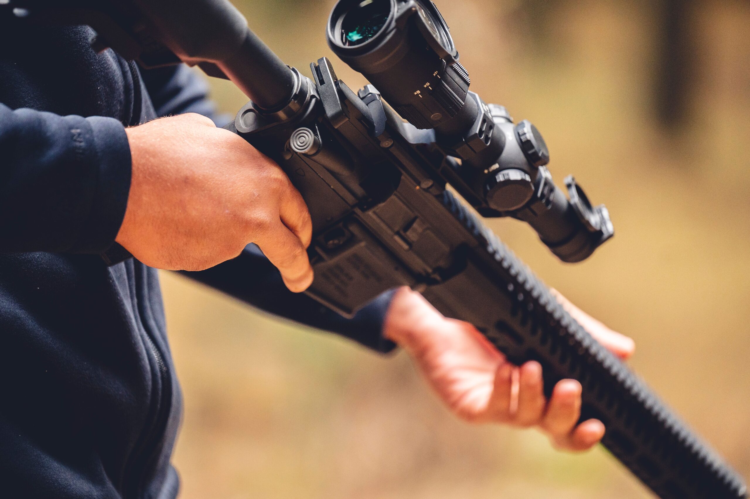 A closeup shot of a man holding the shooting gun at an outdoor shooting range